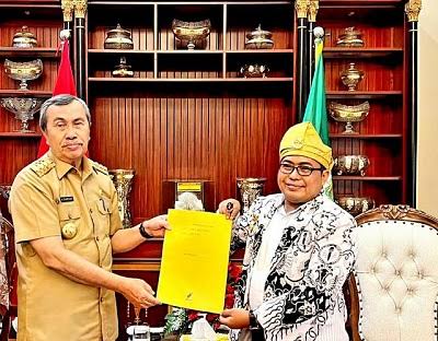 Ketua BKH PGRI Riau, Ekowi saat menyerahkan aspirasi guru honor ke Gubri Syamsuar (foto/int)